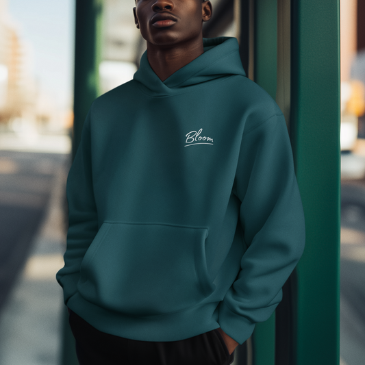 Person wearing a teal hoodie with 'Bloom' logo, standing outdoors.
